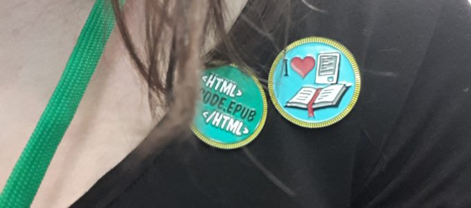 Tightly croppped selfie showing the author with two enamel pins on her sweater. One reads code.epub, the other is a graphic reading I heart ebooks.